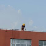operaio lavora su tetto per lavori in quota