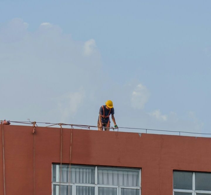 operaio lavora su tetto per lavori in quota